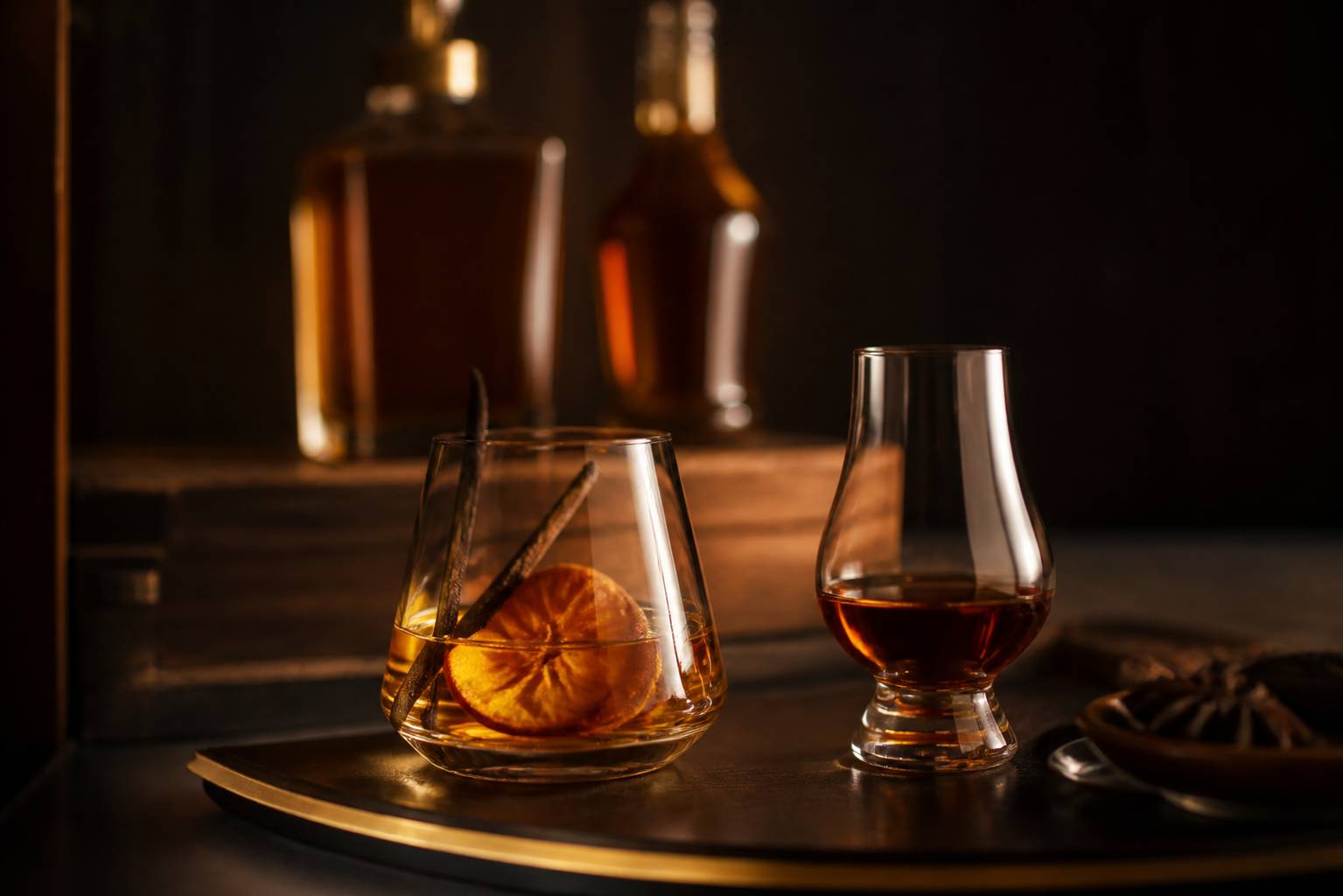 Verre de rhum arrangé avec vanille et verre de rhum vieux sur fond sombre